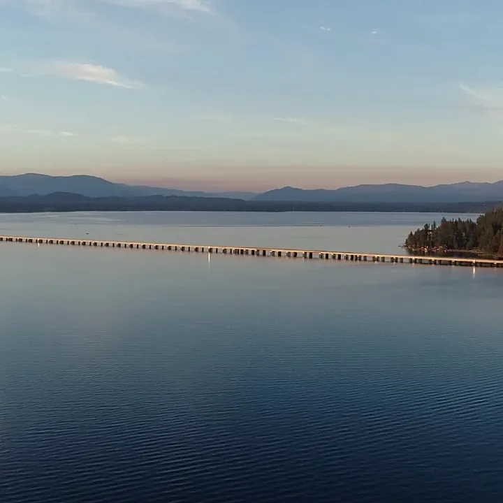 The Long Bridge across Lake Pend Oreille at dusk, with the mountains beyond