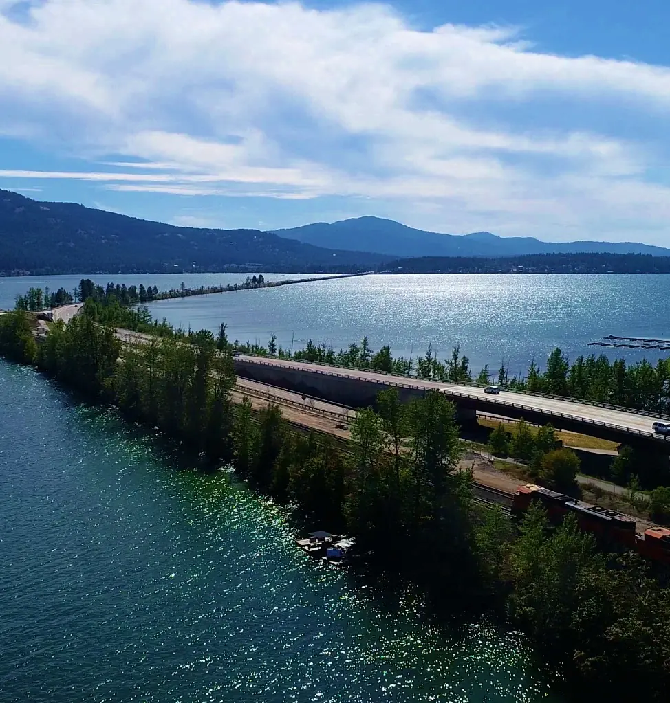 Sandpoint's Long Bridge crossing Lake Pend Oreille, seen from the air, with the highway bridge and a train running alongside